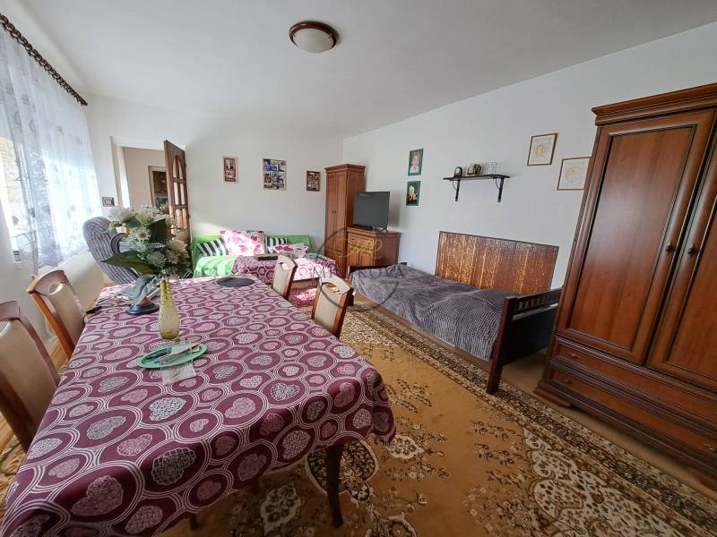 REZERVOVANÉ! Predáme 4-izb. rodinný dom, pozemok 1414 m2, Vráble - Obývacia izba v rodinnom dome s nábytkom, jedálenským stolom a dekoráciami.