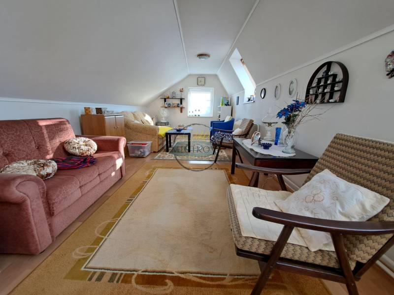 REZERVOVANÉ! Predáme 4-izb. rodinný dom, pozemok 1414 m2, Vráble - Podkrovná obytná miestnosť v rodinnom dome s rozkladacou sedačkou a dekoratívnymi doplnkami.