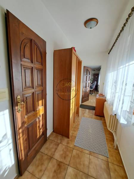 REZERVOVANÉ! Predáme 4-izb. rodinný dom, pozemok 1414 m2, Vráble - Interiér rodinného domu s dlažbou, drevenými dverami a presklenou stenou.