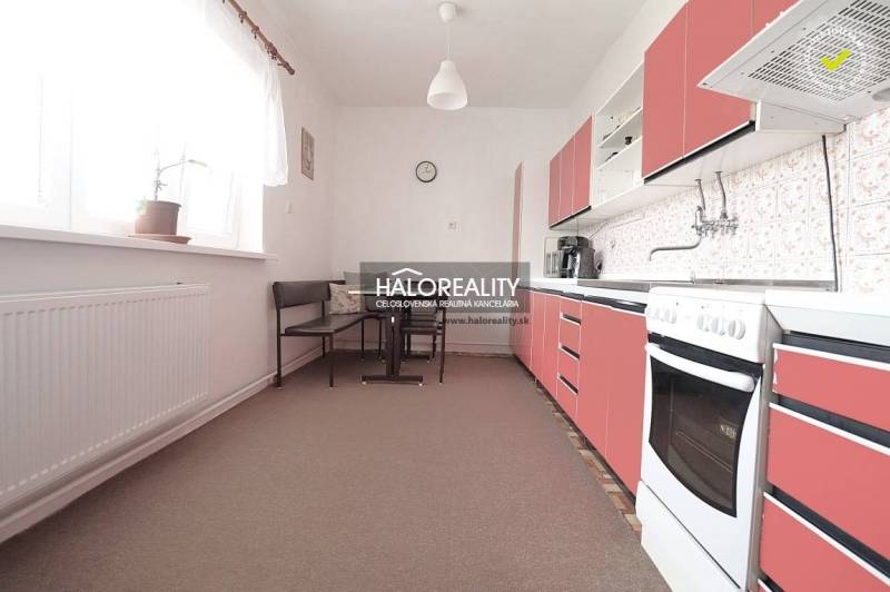 Predaj, rodinný dom Veľký Kýr, šesťizbový s garážou ... - Kuchyňa v rodinnom dome s červenými skrinkami a jedálenským kútom.