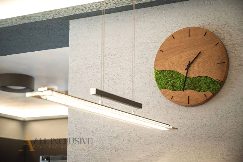 ALL INCLUSIVE I NOVOSTAVBA 4- IZBOVÝ RD SMART HOME - MOSTOVÁ (GA) - Hodiny na stene s dreveným dekorom a zeleným machom v interiéri rodinného domu.