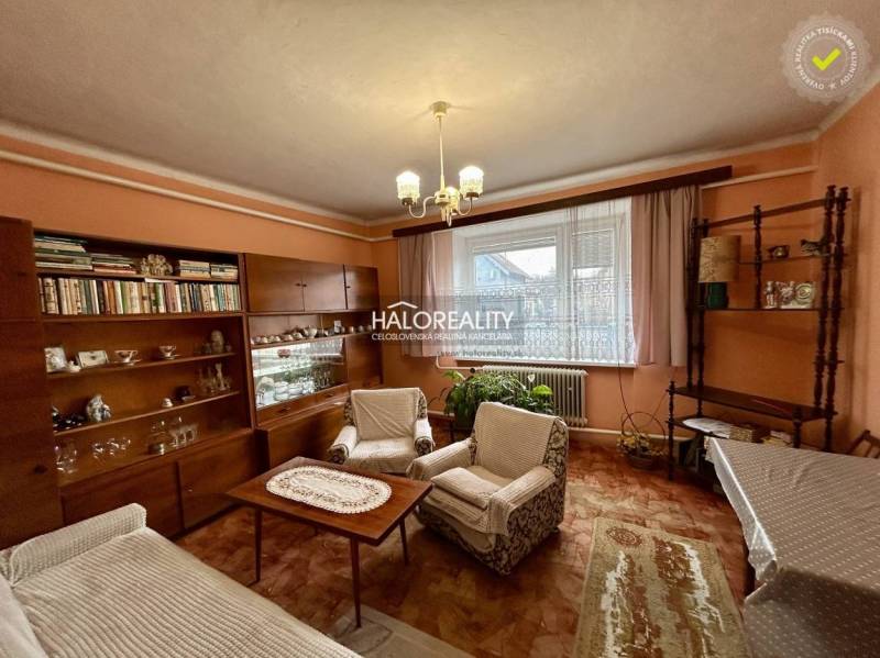 Predaj, rodinný dom Prievidza - EXKLUZÍVNE HALO REALITY - Obývačka rodinného domu s nábytkom z dreveným dekorom a záclonami.