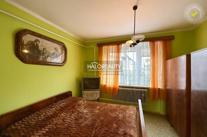 Predaj, rodinný dom Prievidza - EXKLUZÍVNE HALO REALITY - Spálňa v rodinnom dome s posteľou, obrazom, skrinkou a televízorom.