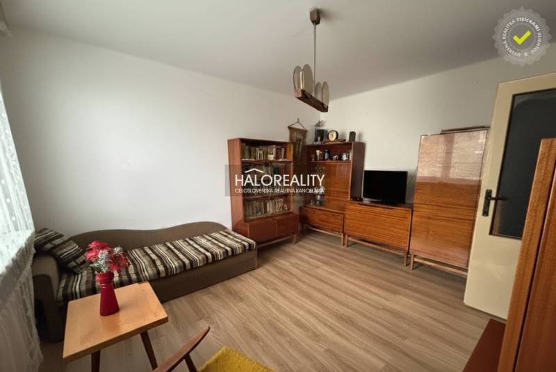 Predaj, trojizbový byt Spišské Vlachy - Obývačka v 3-izbovom byte s podlahou s dreveným dekorom, drevený nábytok, pohovka.