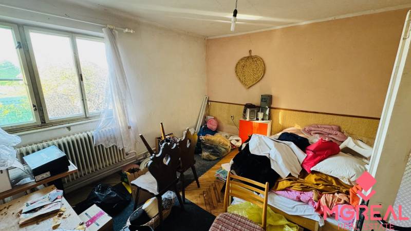 Na predaj 4-izbový rodinný dom v Brodzanoch – pozemok 1236 m² - Miestnosť v rodinnom dome s neporiadkom, okolo sú rôzne predmety a textil.