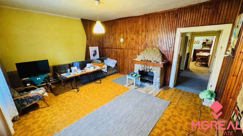 Na predaj 4-izbový rodinný dom v Brodzanoch – pozemok 1236 m² - Obývacia izba v rodinnom dome s krbom a dreveným obkladom stien.