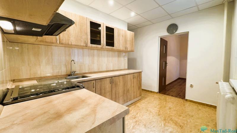 Výborná poloha, skvelá dispozícia – 3-izbový byt v Trebišove - Kuchyňa v 3-izbovom byte s kuchynskou linkou a podlahou s dreveným dekorom.