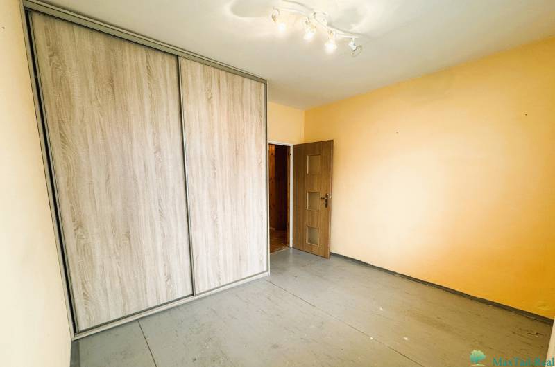 Výborná poloha, skvelá dispozícia – 3-izbový byt v Trebišove - Izba obsahuje vstavanú skriňu a podlahu s dreveným dekorom v 3-izbovom byte.