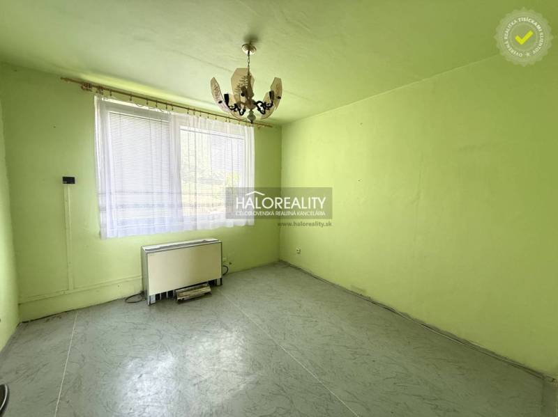 REZERVOVANÉ - Predaj, trojizbový byt Skačany + poliz... - Izba s lustrom, oknom a vykurovacím telesom v 3-izbovom byte.