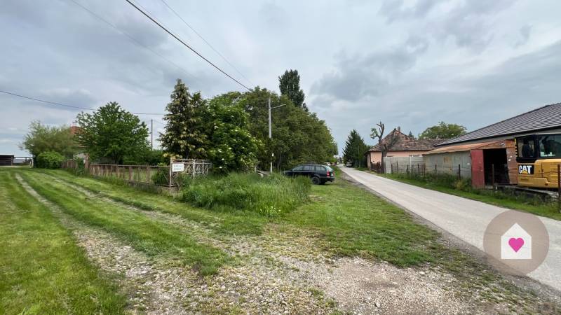 Veľký priestranný pozemok o rozlohe 7445 m2, Jelka  - Cesta v Jelke na Slanej doline vedľa rodinného domu s automobilom a zeleňou.