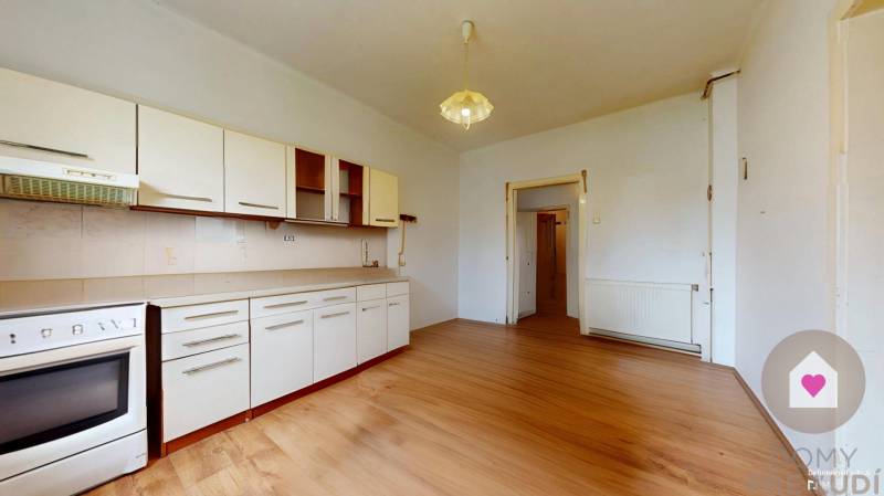 Veľký priestranný pozemok o rozlohe 7445 m2, Jelka  - Kuchyňa v rodinnom dome s drevenou podlahou a bielym nábytkom.