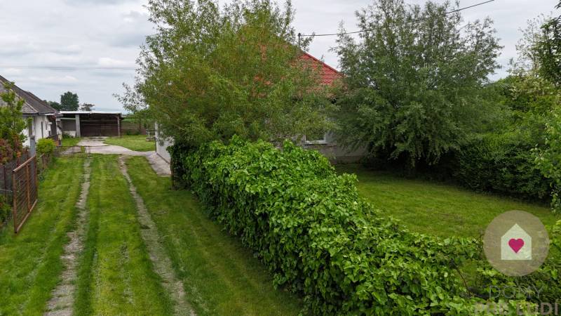 Veľký priestranný pozemok o rozlohe 7445 m2, Jelka  - Záhrada rodinného domu na Slanej doline v Jelke s bujnou zeleňou a príjazdovou cestou.