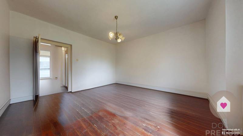 Veľký priestranný pozemok o rozlohe 7445 m2 s RD, Jelka  - Prázdna izba s drevenou podlahou a lustrami v rodinnom dome.