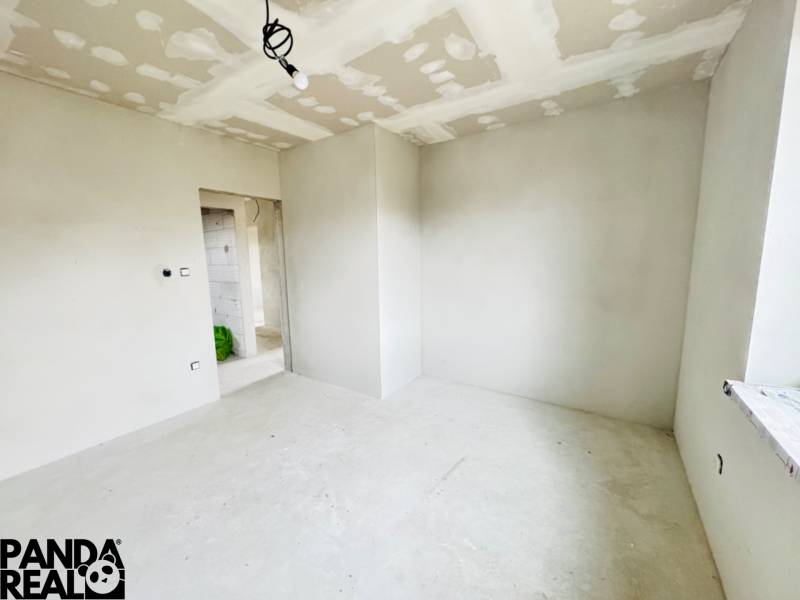 NOVOSTAVBA V CENE 3IZB BYTU - Izba v rodinnom dome so svetlými stenami a holou podlahou.