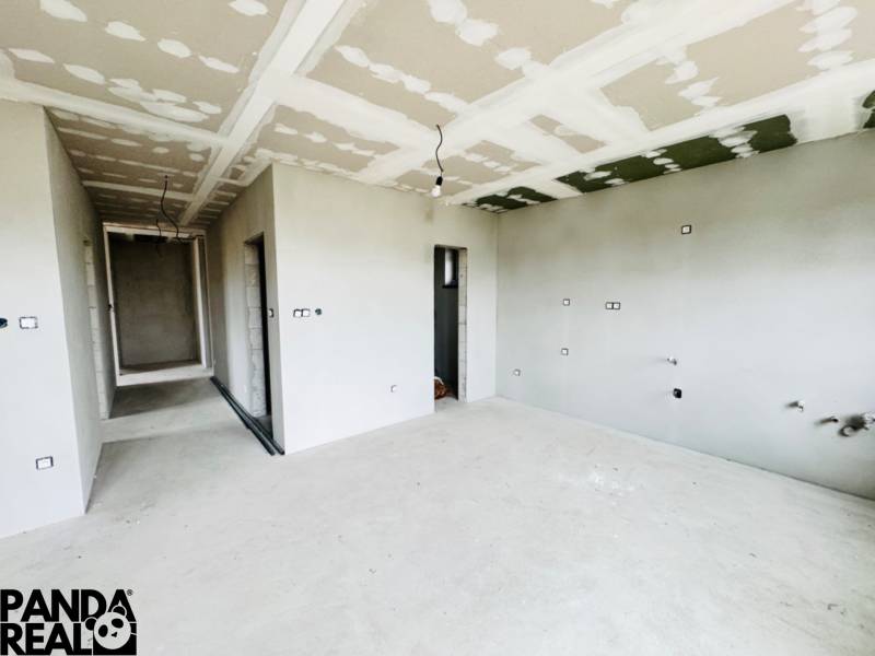 NOVOSTAVBA V CENE 3IZB BYTU - Interiér Rodinného domu s neomietnutými stenami a inštaláciou elektrických zásuviek.