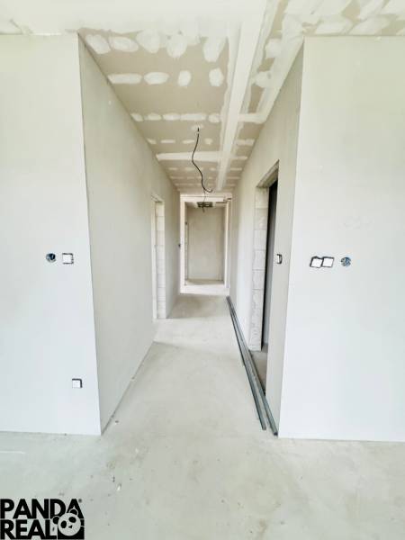 NOVOSTAVBA V CENE 3IZB BYTU - Chodba v rodinnom dome s bielymi stenami, bez podlahovej krytiny.