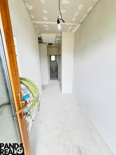 NOVOSTAVBA V CENE 3IZB BYTU - Chodba v rodinnom dome s neomietnutými stenami a rozvodmi elektroinštalácie.