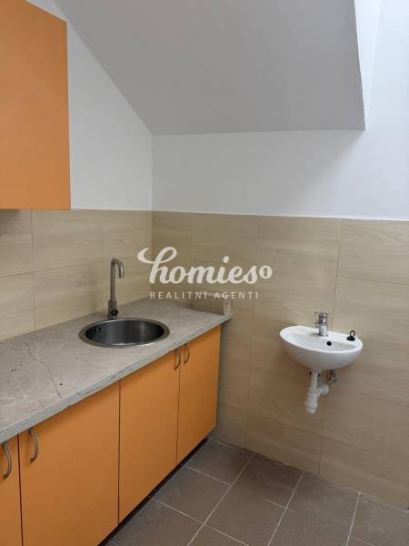 PRENÁJOM OBCHODNÉHO priestoru , NITRA - Štúrova ulica - Kuchynský kút v obchodných priestoroch s oranžovými skrinkami a drezom.