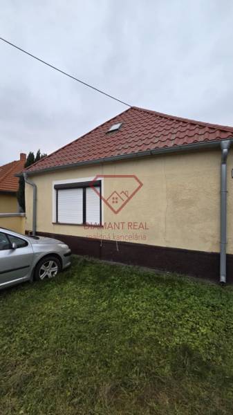 AKCIA - 2 Rodinné domy za cenu jedného obec Veľká Mača  - Rodinný dom na Hlavnej ulici vo Veľkej Mači s automobilom na trávniku.