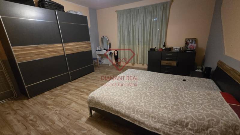 AKCIA - 2 Rodinné domy za cenu jedného obec Veľká Mača  - Spálňa v rodinnom dome s podlahou s dreveným dekorom, šatníkovou skriňou a posteľou.