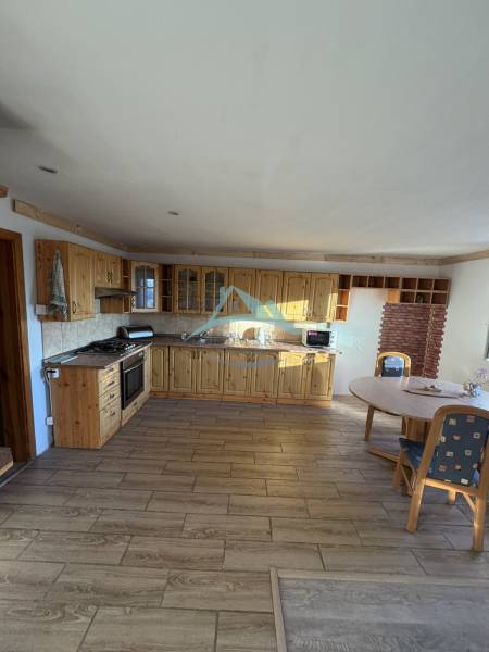 Skrytý raj v srdci prírody - Kuchyňa vo vidieckom štýle s podlahou s dreveným dekorom v rodinnom dome.