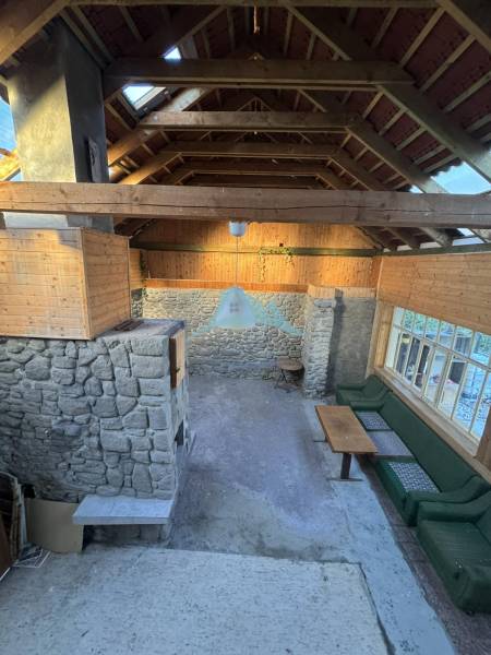 Skrytý raj v srdci prírody - Kamenné steny, drevený strop a sedenie v rodinnom dome.