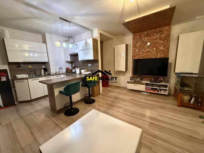 Dvojizbový byt, Považská Bystrica - Stred - Obývačka s kuchyňou, barovým pultom a podlahou s dreveným dekorom v 2-izbovom byte.