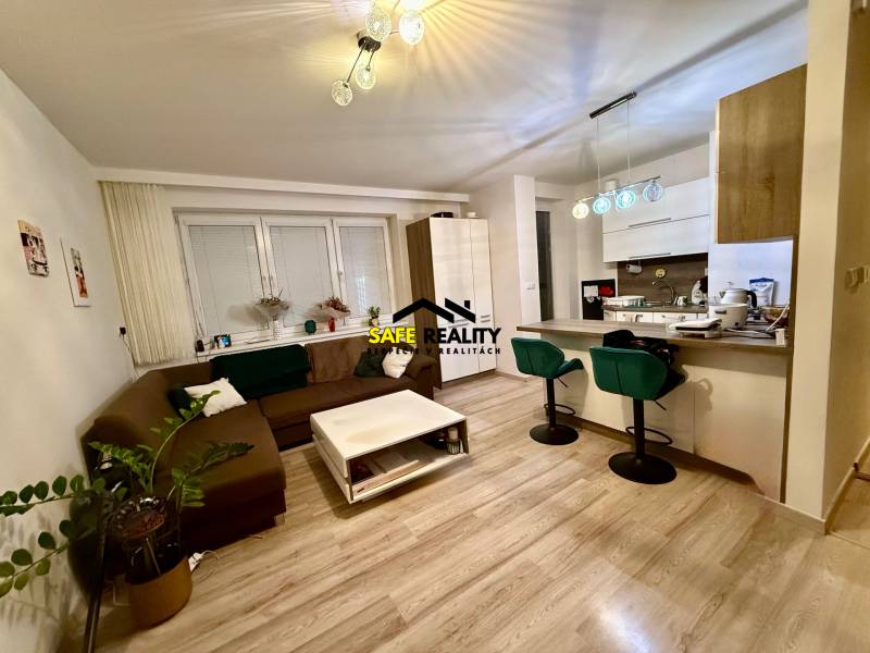 Dvojizbový byt, Považská Bystrica - Stred - Obývacia izba a kuchyňa v 2-izbovom byte s podlahou s dreveným dekorom.