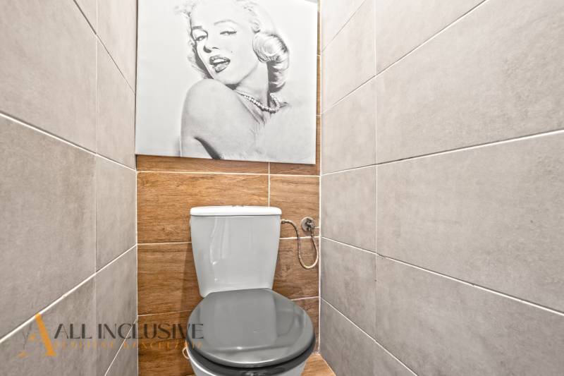 NA PREDAJ 3-IZBOVÝ BYT S PIVNICOU, SENEC - Toaleta v 3-izbovom byte s podlahou s dreveným dekorom a nástennou fotografiou.