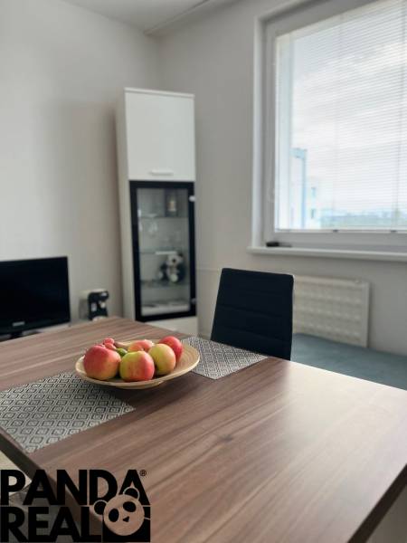 Na prenájom: kompletne zrekonštruovaný 1-izb. byt s balkónom sídl. JUH - Jedálenský stôl s misou jabĺk, stolička, sklenená vitrína, okno.