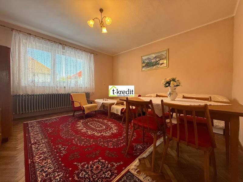 PREDAJ - RODINNÝ DOM - MACHULINCE - Obývačka v rodinnom dome s kobercom, dreveným nábytkom a podlahou s dreveným dekorom.