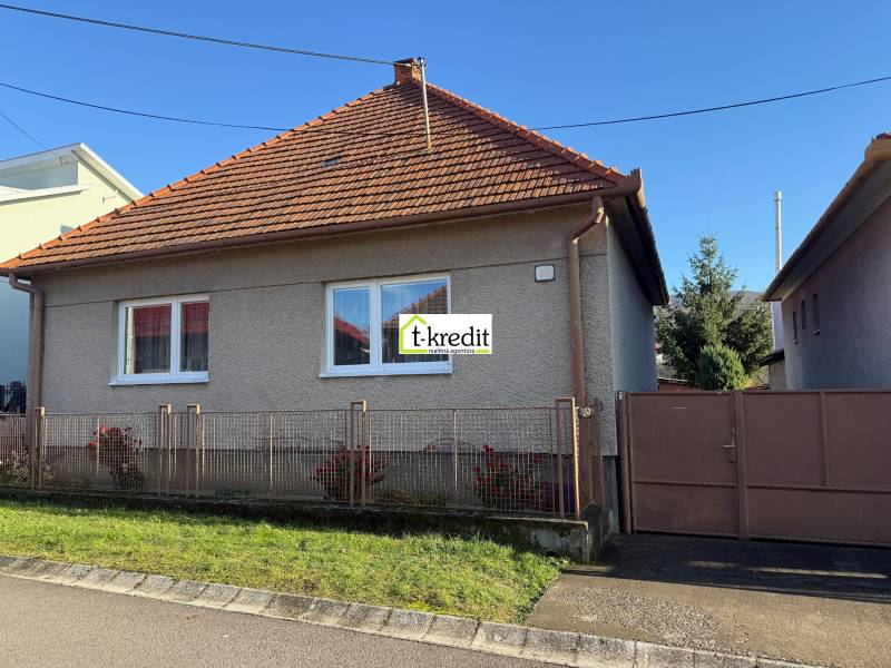 PREDAJ - RODINNÝ DOM - MACHULINCE - Rodinný dom v Machulinciach s červenou škridlovou strechou, bielymi oknami a záhradkou.