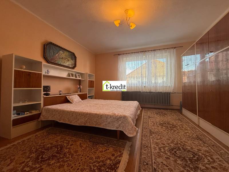 PREDAJ - RODINNÝ DOM - MACHULINCE - Spálňa s kobercami, posteľou, policami a obrazom v rodinnom dome.