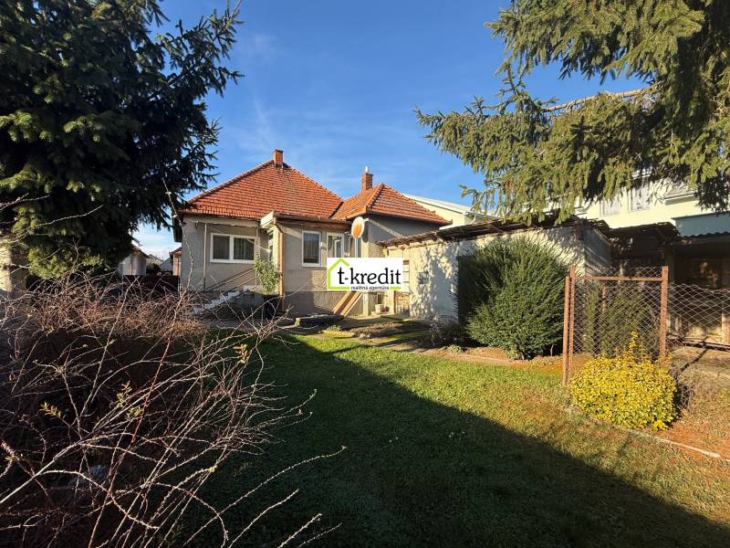 PREDAJ - RODINNÝ DOM - MACHULINCE - Rodinný dom v Machulinciach s červenou škridlovou strechou, záhradou a vzrastlými stromami.