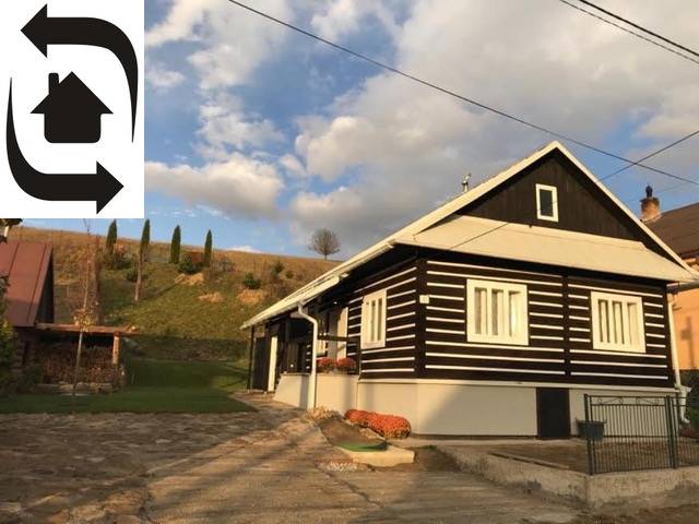 Rekreačná drevenica v obci Legnava na predaj - Chata v Legnave s dreveným obkladom a dláždeným dvorom, obklopená prírodou a kopcami.