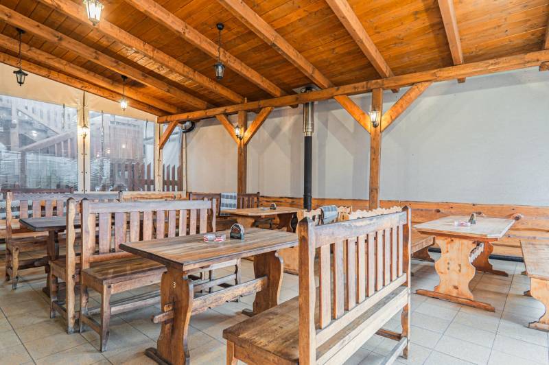 Predaj Exkluzívna ponuka elegantného penziónu s hostincom - Drevený interiér reštaurácie s lavicami a stolmi v hotelovom a penziónovom štýle.
