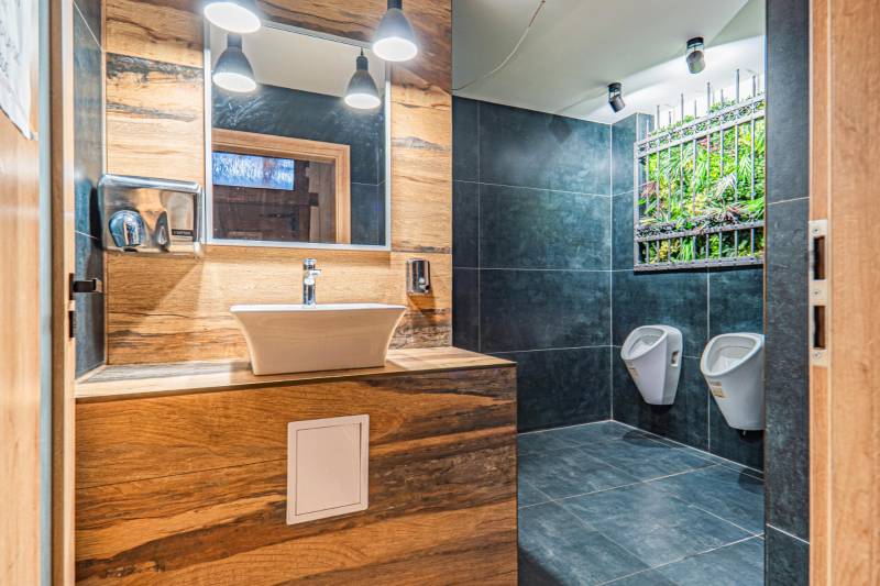 Predaj Exkluzívna ponuka elegantného penziónu s hostincom - Kúpeľňa s umývadlom, tmavou dlažbou, vertikálnou záhradou a podlahou s dreveným dekorom. Hotely a penzióny.