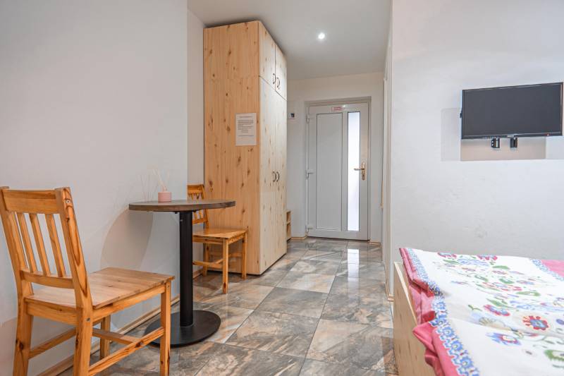 Predaj Exkluzívna ponuka elegantného penziónu s hostincom - Izba v hoteloch a penziónoch s dlažbou, dreveným stolom, stoličkami, TV a posteľou.