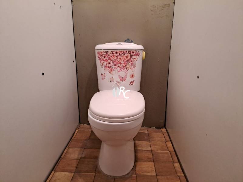 REZERVOVANÉ 2-izbový byt s nádherným výhľadom v pôvodnom stave   - Toaleta so vzorom kvetov a podlahou s dreveným dekorom v 2-izbovom byte.