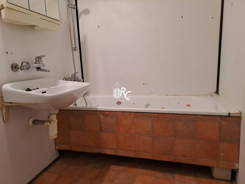 REZERVOVANÉ 2-izbový byt s nádherným výhľadom v pôvodnom stave   - Kúpeľňa s vaňou a umývadlom v 2-izbovom byte, obklady s hnedým dekorom.