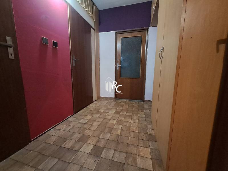 REZERVOVANÉ 2-izbový byt s nádherným výhľadom v pôvodnom stave   - Chodba v 2-izbovom byte s podlahou s dreveným dekorom a úložným priestorom.