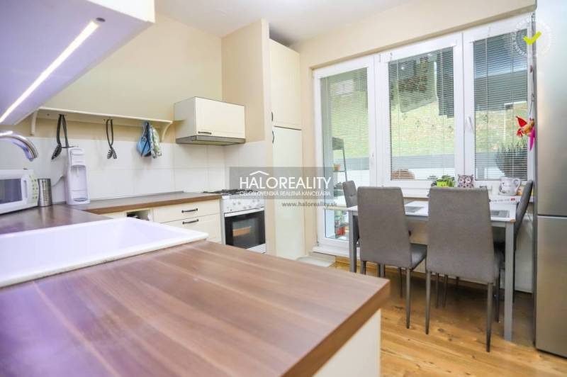 REZERVOVANÉ - Predaj, dvojizbový byt Považská Bystri... - Kuchyňa v 2-izbovom byte s podlahou s dreveným dekorom, jedálenským stolom a spotrebičmi.