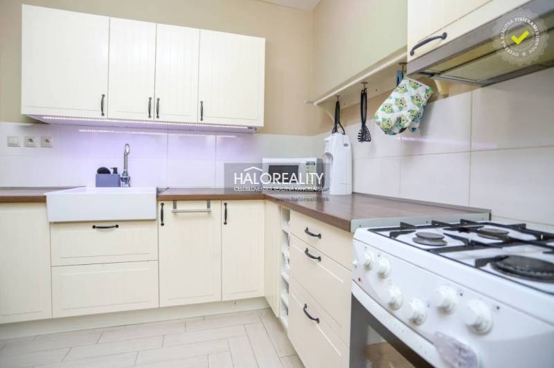 REZERVOVANÉ - Predaj, dvojizbový byt Považská Bystri... - Kuchyňa v 2-izbovom byte s rustikálnymi skrinkami a plynovým sporákom, svetlý dizajn.