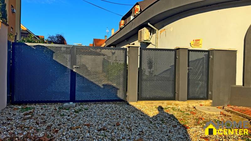 Na predaj unikátna dvojpodlažná budova na podnikanie aj bývanie - Kovová brána pri budove v Komárne na štrkovom pozemku pri dome.