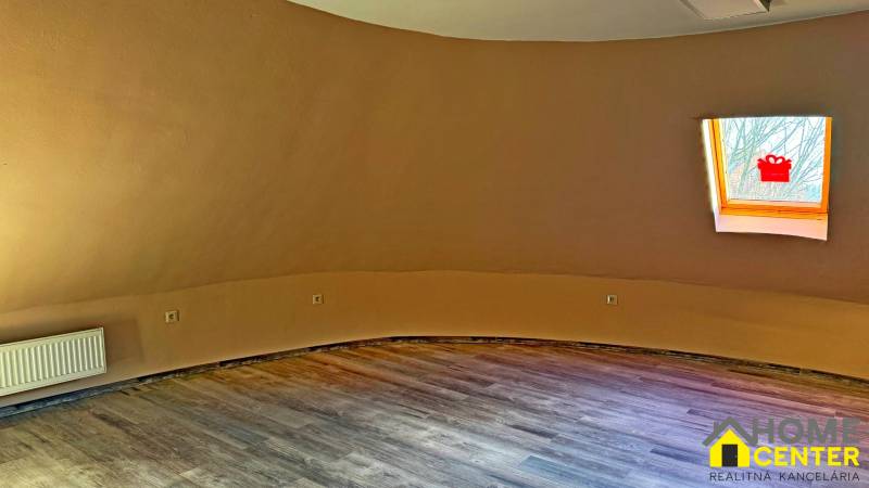 Na predaj unikátna dvojpodlažná budova na podnikanie aj bývanie - Miestnosť v budove s podlahou s dreveným dekorom a strešným oknom.