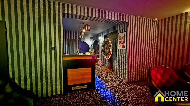 Na predaj unikátna dvojpodlažná budova na podnikanie aj bývanie - Interiér budovy s čierno-bielymi pruhovanými tapetami a vzorovaným kobercom.