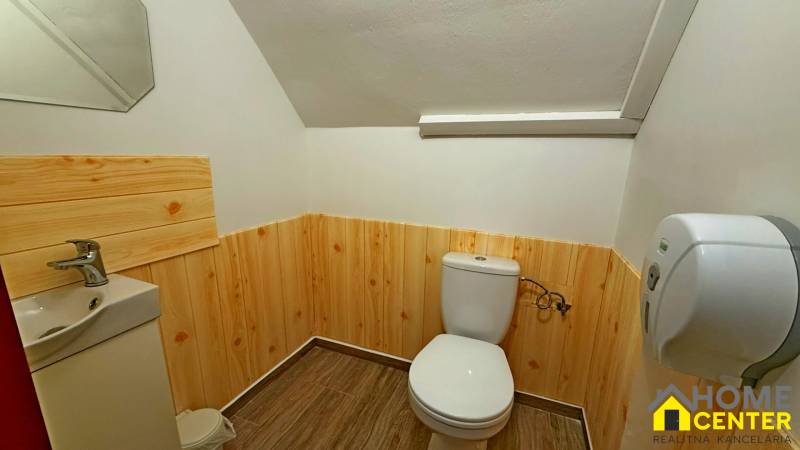 Na predaj unikátna dvojpodlažná budova na podnikanie aj bývanie - Kúpeľňa s dreveným obkladom, sanitou a podlahou s dreveným dekorom, zrkadlo na stene.