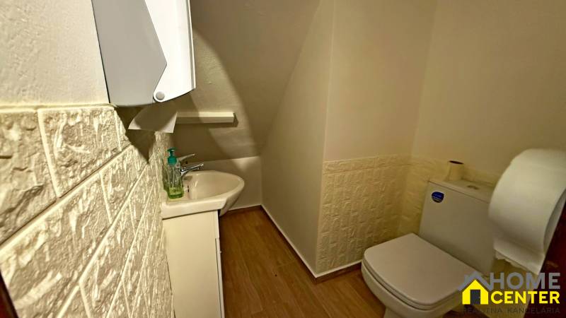 Na predaj unikátna dvojpodlažná budova na podnikanie aj bývanie - Kúpeľňa s umývadlom, toaletou, podlahou s dreveným dekorom a textúrovanými stenami.