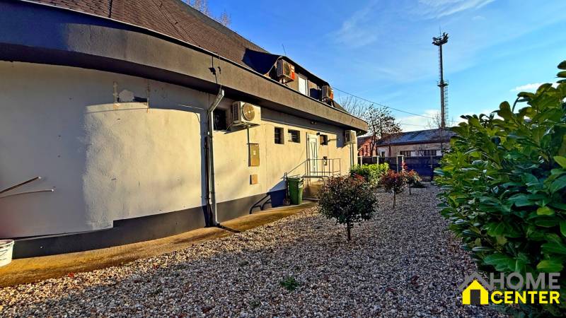 Na predaj unikátna dvojpodlažná budova na podnikanie aj bývanie - Budova v Komárne s klimatizáciou, čo obklopuje štrková plocha a kríky.