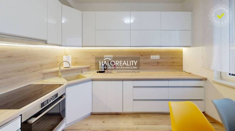 Predaj, dvojizbový byt Zvolen, kompletná rekonštrukc... - Biela kuchyňa s podlahou s dreveným dekorom v 2-izbovom byte s moderným osvetlením.